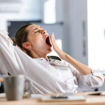 Jeune femme fatiguée qui baille à son bureau